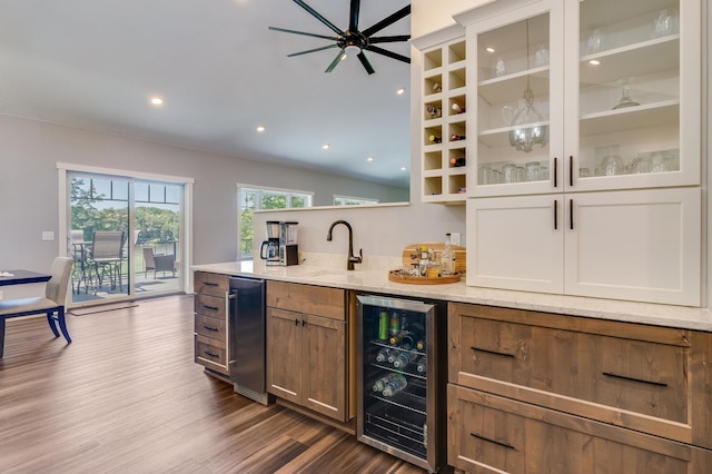 bar featuring beverage cooler, dark wood finished floors, ceiling fan, wet bar, and a sink