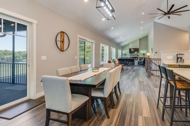 dining space featuring high vaulted ceiling, recessed lighting, baseboards, and wood finished floors