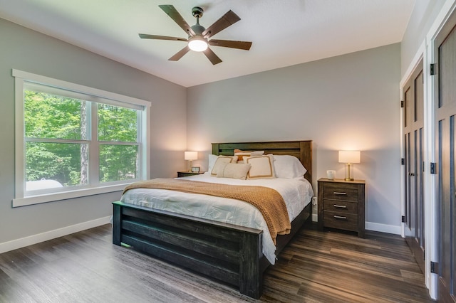 bedroom featuring dark wood-style floors, ceiling fan, and baseboards