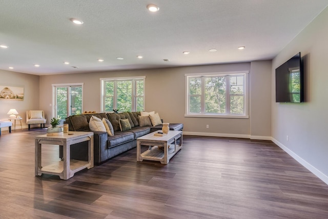 living room featuring dark wood-style floors, recessed lighting, a textured ceiling, and baseboards