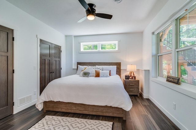 bedroom featuring visible vents, dark wood finished floors, baseboards, and ceiling fan