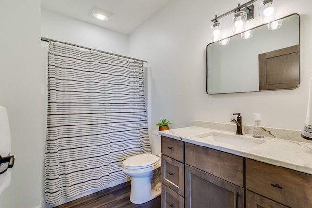 bathroom with toilet, a shower with shower curtain, wood finished floors, and vanity