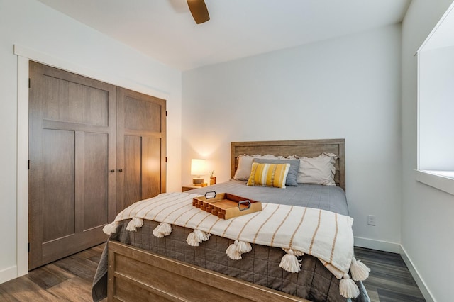 bedroom with dark wood-style floors, a closet, baseboards, and a ceiling fan