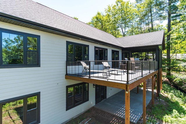 back of house with a shingled roof, stairs, and a deck