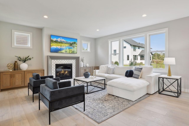 living room with light hardwood / wood-style floors and a tile fireplace