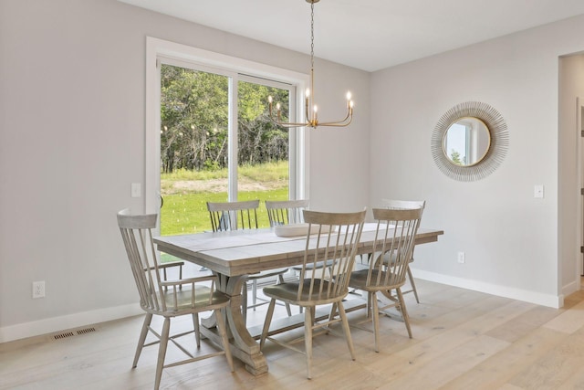 dining room with a chandelier and light hardwood / wood-style floors