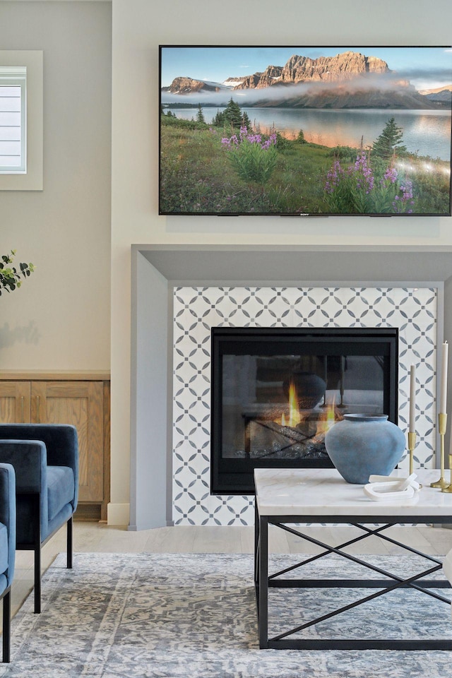 room details featuring a wainscoted wall and a tiled fireplace