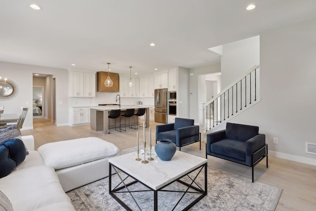 living area with visible vents, recessed lighting, and baseboards