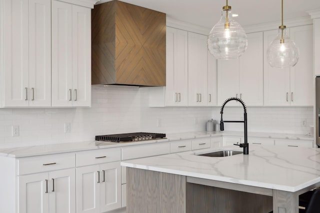 kitchen with white cabinetry, premium range hood, gas cooktop, and a sink