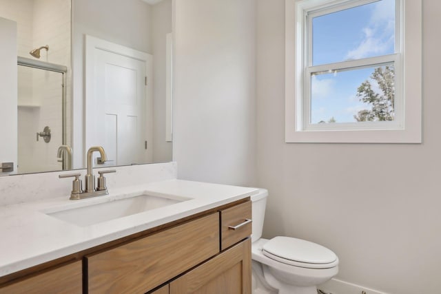 bathroom with a shower with door, toilet, and vanity