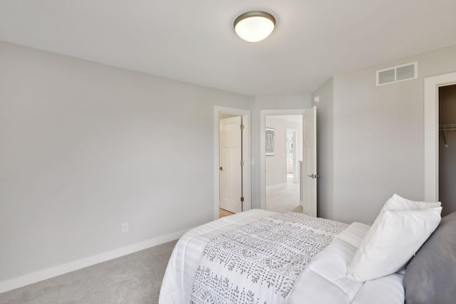 carpeted bedroom featuring visible vents, baseboards, and a closet