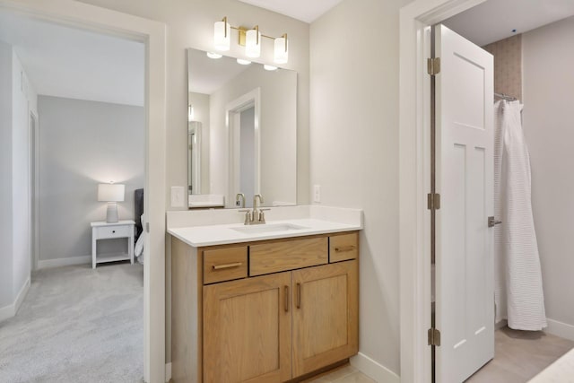 bathroom with curtained shower, baseboards, and vanity