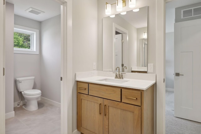 bathroom with visible vents, toilet, vanity, and baseboards