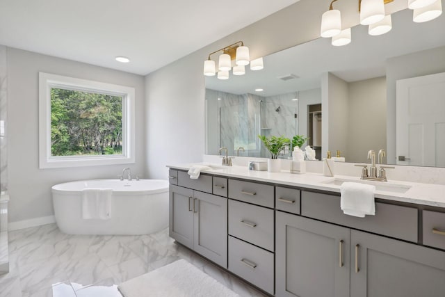 full bath with a sink, marble finish floor, a shower stall, and double vanity