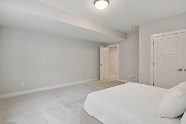 bedroom featuring visible vents, light colored carpet, and baseboards