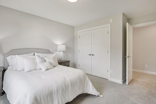 carpeted bedroom with baseboards and a closet