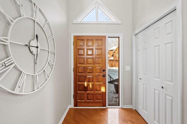 entryway featuring hardwood / wood-style flooring and a towering ceiling