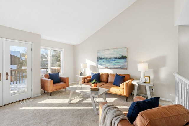 carpeted living room featuring high vaulted ceiling and french doors