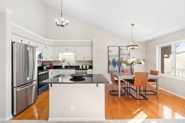 kitchen featuring a center island, light hardwood / wood-style flooring, a notable chandelier, stainless steel appliances, and white cabinets