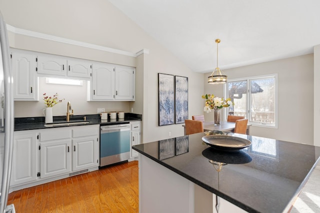 kitchen with vaulted ceiling, sink, white cabinets, stainless steel dishwasher, and light hardwood / wood-style floors