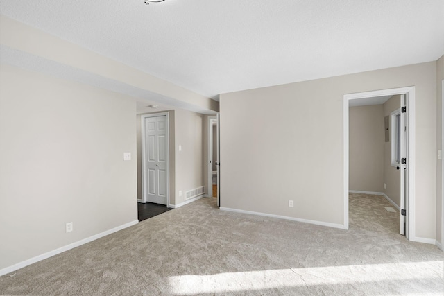 unfurnished room with light carpet and a textured ceiling