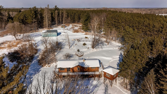 snowy aerial view with a wooded view