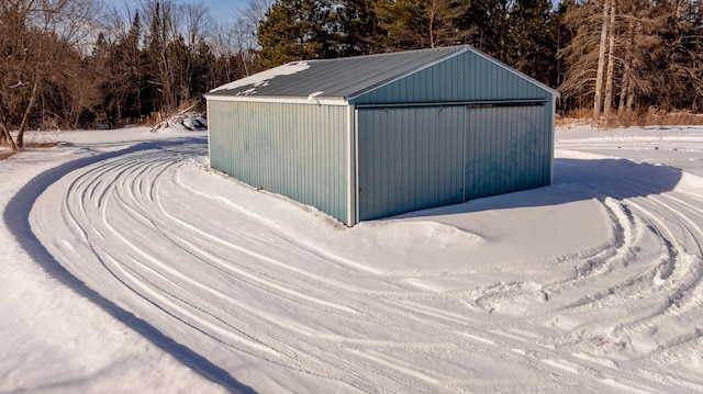 snow covered structure with an outbuilding