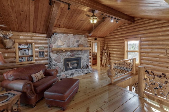 living area with rustic walls, lofted ceiling with beams, hardwood / wood-style flooring, wooden ceiling, and a fireplace