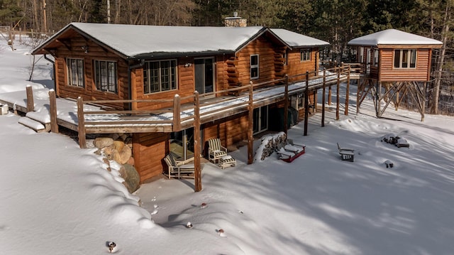 3324 52nd St SW, Pequot Lakes, MN 56472 - snow covered back of property with a deck and view of wooded area