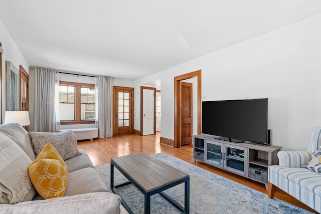 living area featuring light wood-style flooring and baseboards