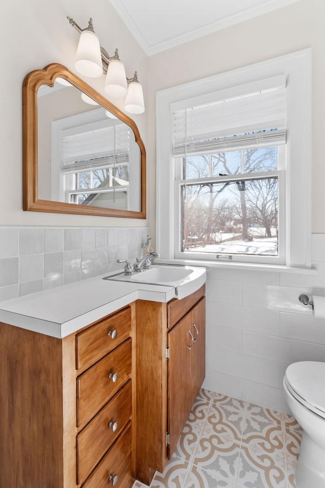 bathroom featuring tile walls, toilet, ornamental molding, vanity, and tile patterned flooring