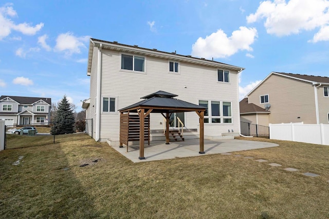 back of property with a gazebo, a patio area, and a lawn