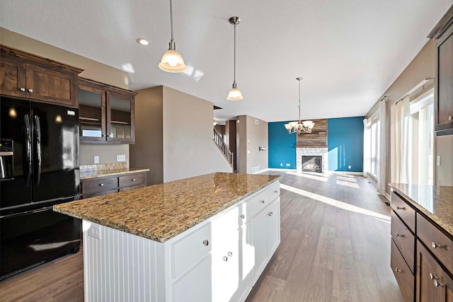 kitchen featuring decorative light fixtures, white cabinets, hardwood / wood-style flooring, dark brown cabinetry, and black fridge with ice dispenser