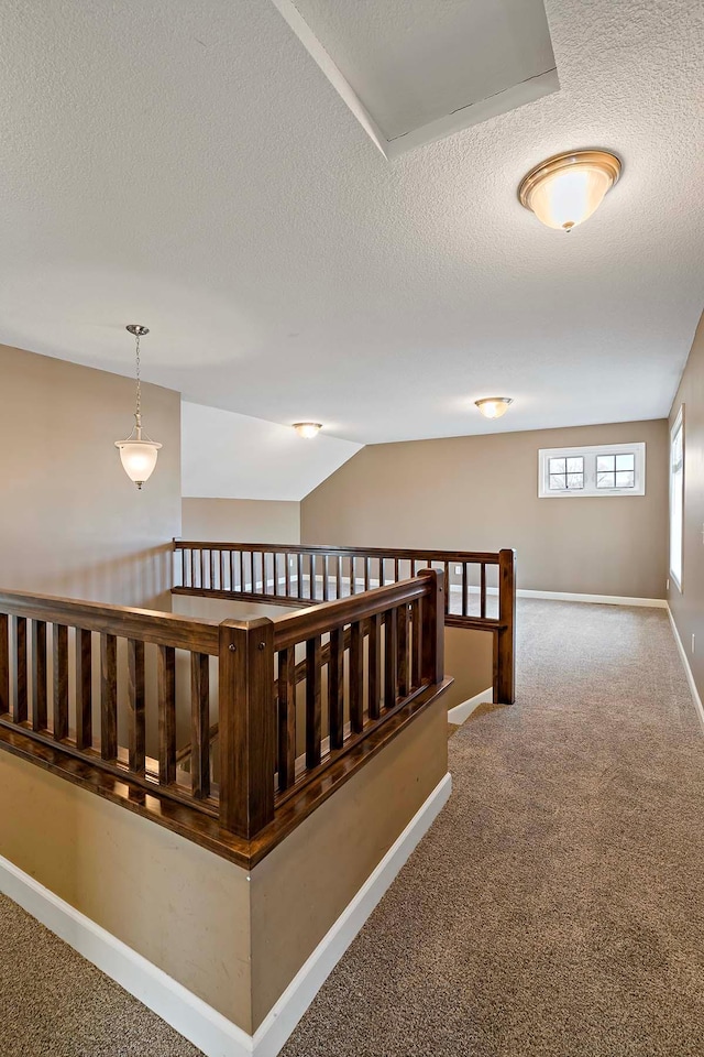 hall with carpet flooring and a textured ceiling