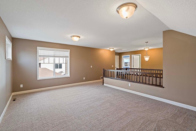 carpeted spare room featuring a textured ceiling