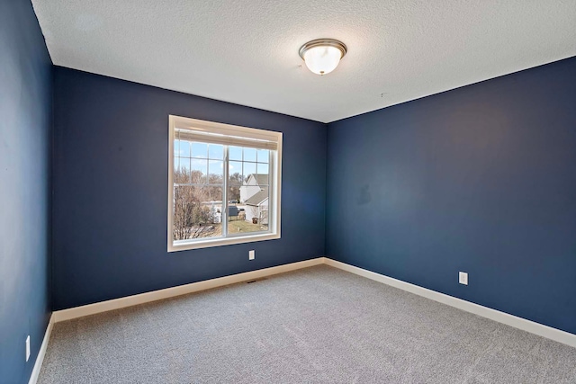 carpeted spare room featuring a textured ceiling