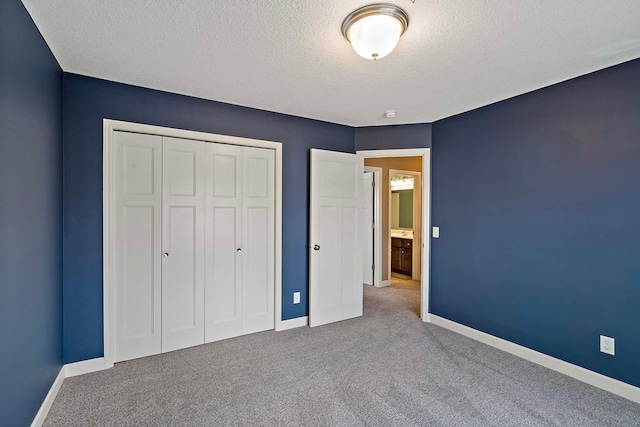 unfurnished bedroom featuring light colored carpet, a closet, and a textured ceiling