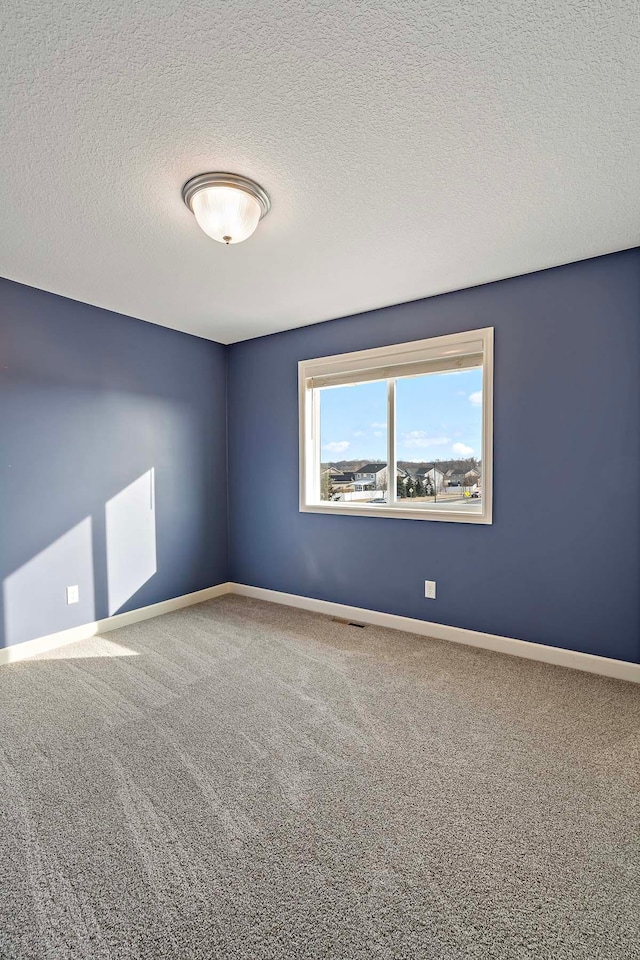 unfurnished room with carpet floors and a textured ceiling