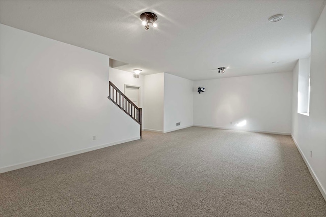 carpeted spare room featuring a textured ceiling