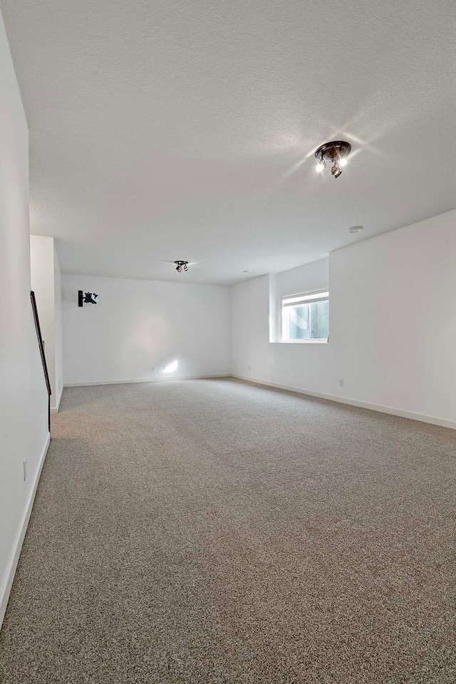 unfurnished room with carpet flooring and a textured ceiling