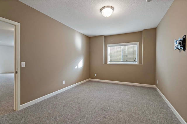 spare room featuring a textured ceiling and carpet