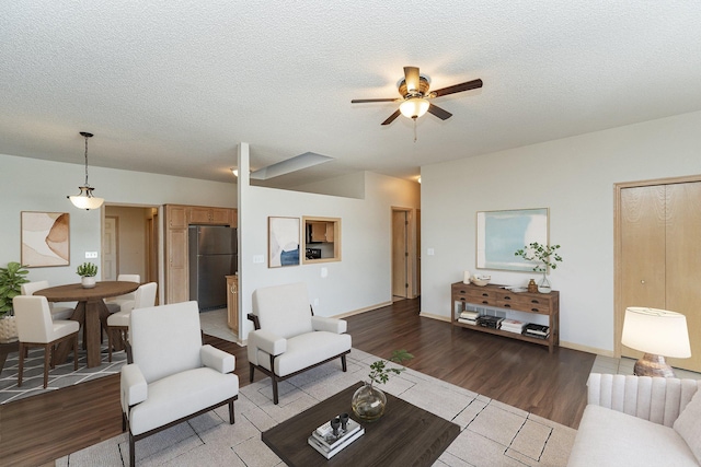 living room with hardwood / wood-style flooring, ceiling fan, and a textured ceiling