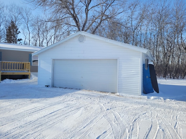 snow covered garage featuring a detached garage