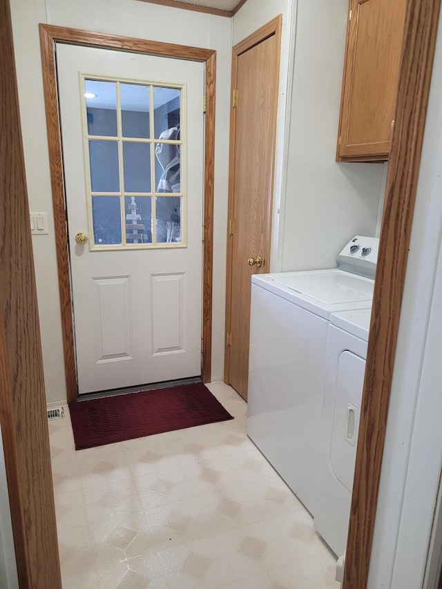 laundry room featuring washing machine and dryer, cabinet space, visible vents, and light floors