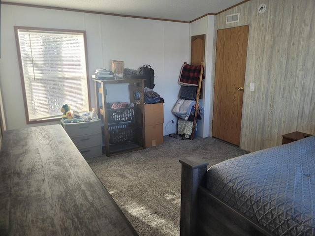 carpeted bedroom featuring visible vents and ornamental molding