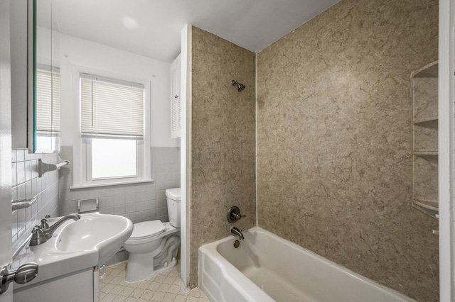 bathroom featuring tile walls, toilet, wainscoting, shower / bathing tub combination, and vanity