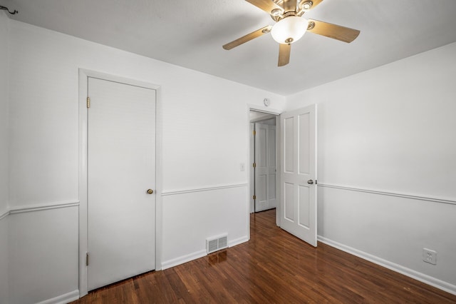 unfurnished bedroom featuring a ceiling fan, wood finished floors, visible vents, and baseboards