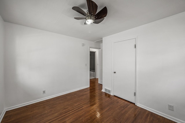 unfurnished bedroom featuring a ceiling fan, visible vents, wood finished floors, and baseboards