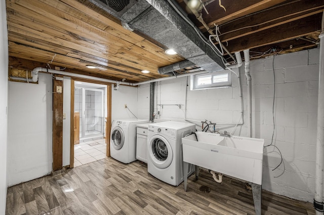 laundry area featuring a sink, light wood-style flooring, laundry area, and washer and clothes dryer