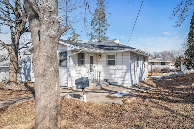 back of property featuring roof with shingles